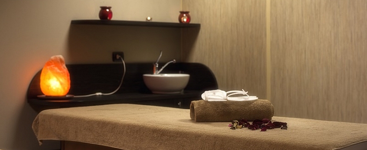 Image of a relaxing massage table setup complete with an orange glowing light and towels.