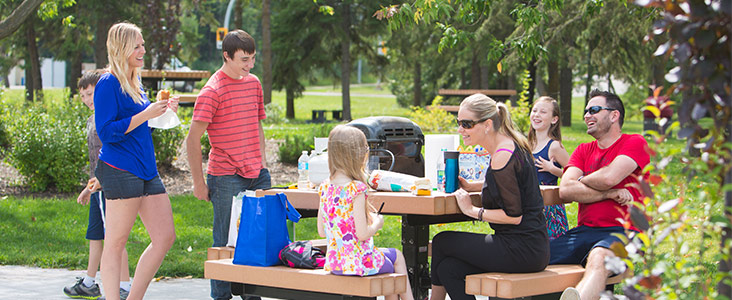 Family having a picnic on a park bench.