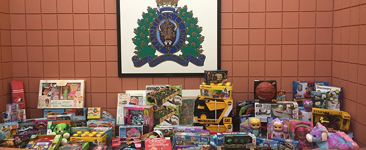 Mountain of toys piled up in front of the RCMP logo at the St. Albert RCMP Detachment