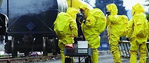 Emergency response personnel dressed in yellow haz mat suits responding to a train derailment