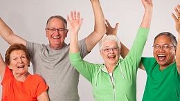 4 seniors with hands raised laughing