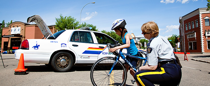 RCMP Officer helping girl on bike