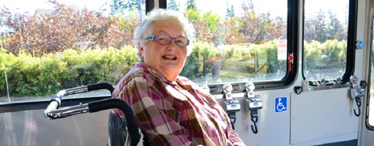 Photo of a senior woman sitting on a Handibus smiling