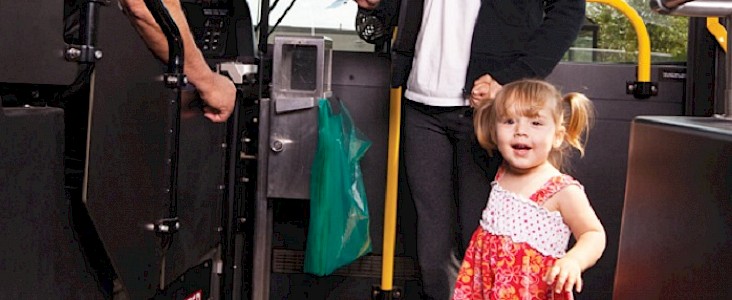 Photo of a little girl standing at the front of a bus