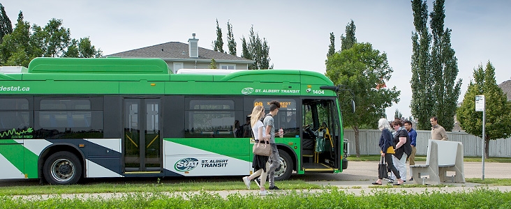 Group of people at a bus stop entering a St. Albert Transit Bus