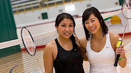 Two women with badminton racquets