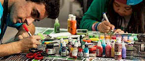 Two youths creating art with markers and paint